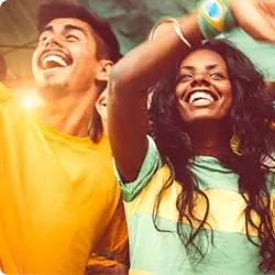 Casal de verde e amarelo vibrando na torcida.