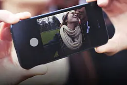 Imagem de um celular com uma foto de um casal na tela.