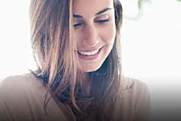 Mulher sorridente usando o celular.