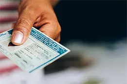 Imagem de uma mão segurando um documento pessoal.