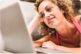 Fotografia. Mulher entre 30 e 40 anos vendo vídeo no notebook.