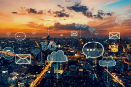 imagem de uma cidade iluminada sobreposta por ícones de e-mail, nuvem, wi-fi e 5g