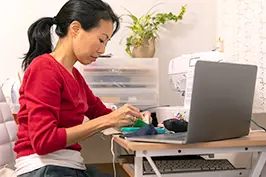 Imagem de uma moça estudando com um computador.