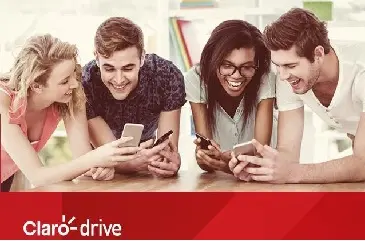Imagem de pessoas jovens apoiadas em uma mesa mexendo em celulares.