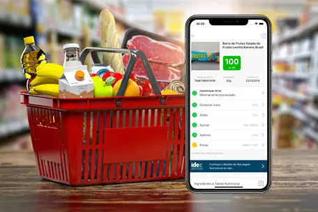 Imagem de um celular com uma lista de compras no supermercado e uma cesta cheia de produtos.