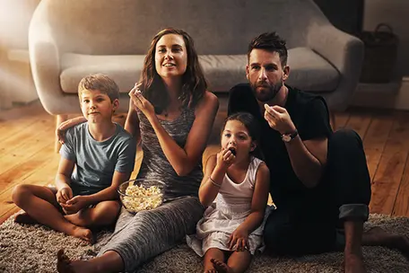 Imagem com familia olhando tv